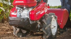 Closeup of tiller loosening soil on a corn field.  